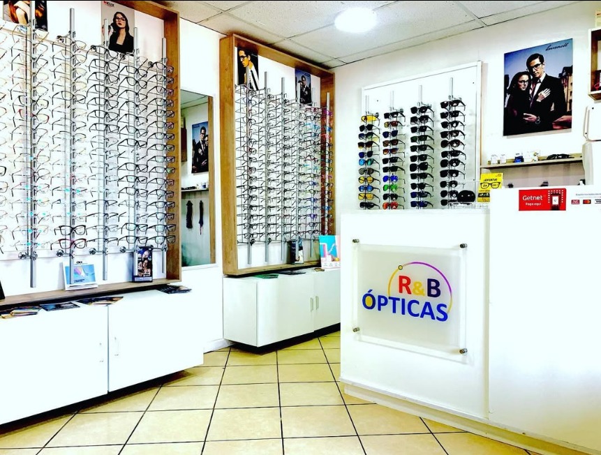 Interior de la tienda R&B Ópticas con exhibidores de marcos